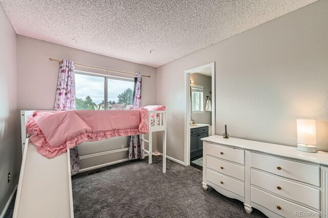 4567 Flanders Way, Denver, CO 80249 - bedroom featuring dark carpet, a textured ceiling, and ensuite bathroom