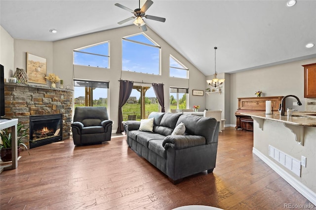 8101 Wynstone Dr, Windsor, CO 80550 - living room with a chandelier, ceiling fan, hardwood / wood-style flooring, a fireplace, and high vaulted ceiling