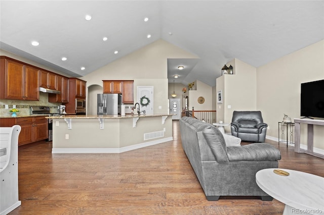 8101 Wynstone Dr, Windsor, CO 80550 - living area with lofted ceiling, light wood finished floors, recessed lighting, and baseboards