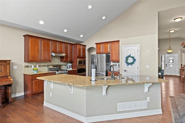 8101 Wynstone Dr, Windsor, CO 80550 - kitchen with stainless steel appliances, a sink, a breakfast bar area, under cabinet range hood, and recessed lighting
