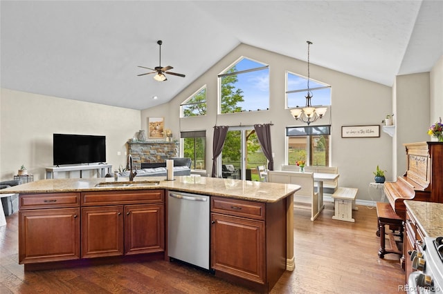 8101 Wynstone Dr, Windsor, CO 80550 - kitchen with appliances with stainless steel finishes, a sink, open floor plan, a ceiling fan, and a fireplace