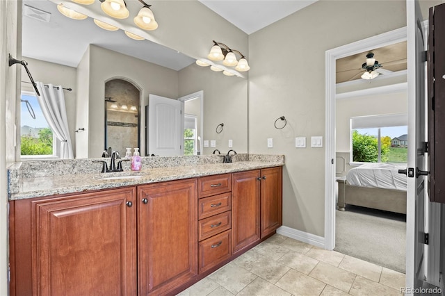 8101 Wynstone Dr, Windsor, CO 80550 - ensuite bathroom with double vanity, a ceiling fan, baseboards, and tile patterned floors