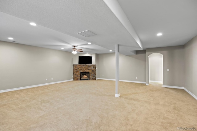 8101 Wynstone Dr, Windsor, CO 80550 - below grade area with light colored carpet, a fireplace, baseboards, recessed lighting, and arched walkways