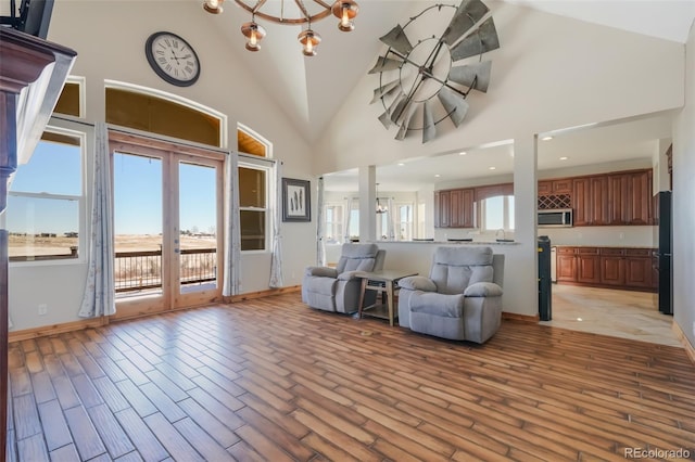 living room featuring a notable chandelier and high vaulted ceiling