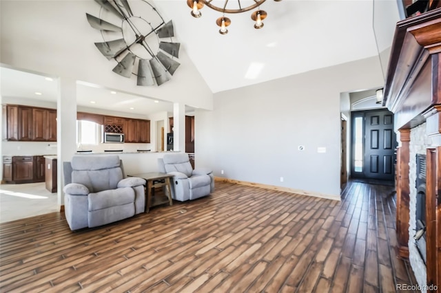 living room with hardwood / wood-style floors, high vaulted ceiling, and an inviting chandelier