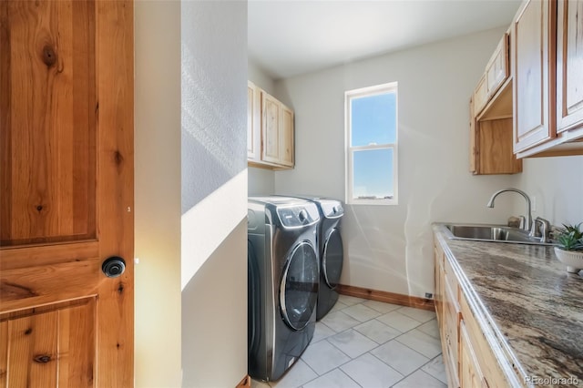 clothes washing area with cabinets, independent washer and dryer, light tile patterned flooring, and sink