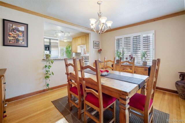 2995 Albion St, Denver, CO 80207 - dining area featuring a chandelier, ornamental molding, baseboards, and light wood-style floors