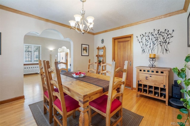 2995 Albion St, Denver, CO 80207 - dining space featuring arched walkways, light wood finished floors, an inviting chandelier, and crown molding