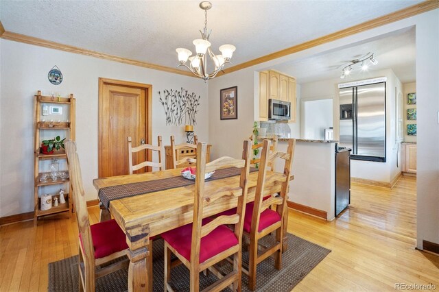 2995 Albion St, Denver, CO 80207 - dining area with an inviting chandelier, ornamental molding, baseboards, and light wood-type flooring