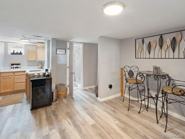 2995 Albion St, Denver, CO 80207 - dining area with baseboards, light wood finished floors, indoor bar, and beverage cooler