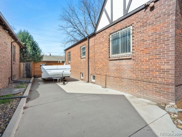 2995 Albion St, Denver, CO 80207 - view of side of home with brick siding, fence, and a patio