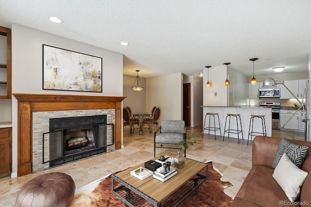 13950 E Oxford Pl Unit B105, Aurora, CO 80014 - living area featuring a textured ceiling, recessed lighting, and a stone fireplace