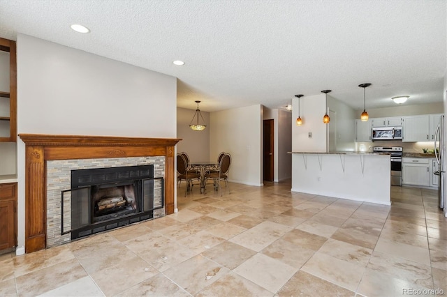 13950 E Oxford Pl Unit B105, Aurora, CO 80014 - living area with a textured ceiling, a stone fireplace, and recessed lighting