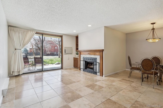 13950 E Oxford Pl Unit B105, Aurora, CO 80014 - living area featuring a textured ceiling, recessed lighting, a tiled fireplace, baseboards, and light tile patterned flooring