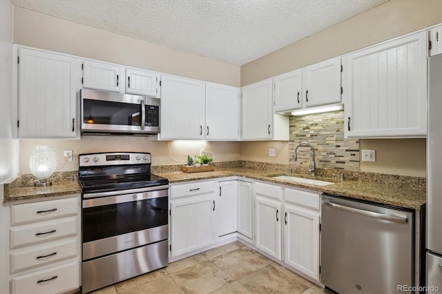 13950 E Oxford Pl Unit B105, Aurora, CO 80014 - kitchen with stainless steel appliances, a sink, light stone counters, white cabinets, and a textured ceiling
