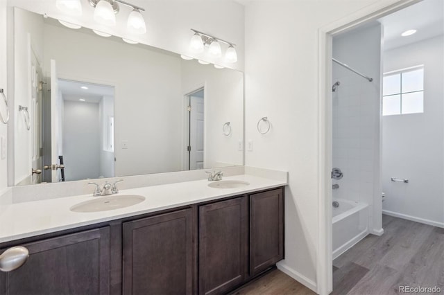 bathroom with vanity, tiled shower / bath combo, and hardwood / wood-style flooring