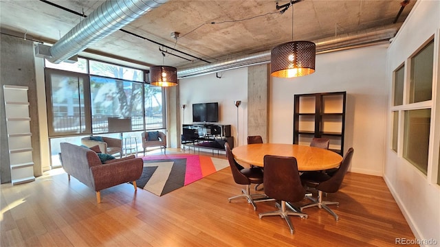 dining area with expansive windows and wood-type flooring