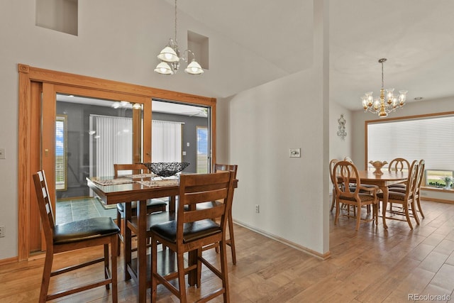 dining area with light wood-type flooring and a chandelier