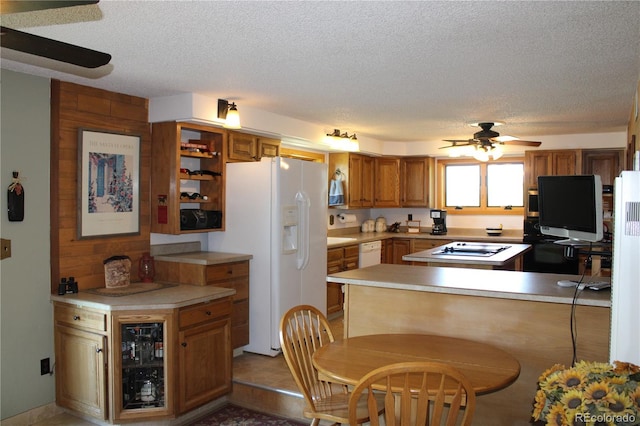 kitchen with a textured ceiling, kitchen peninsula, ceiling fan, and white appliances