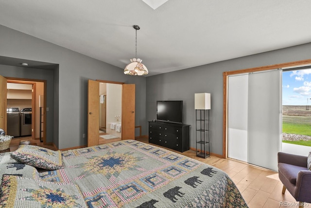 bedroom with washer and dryer, vaulted ceiling, light hardwood / wood-style flooring, and ensuite bath