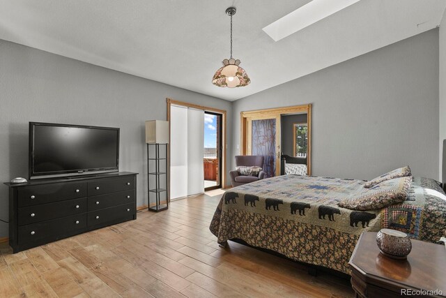 bedroom with light wood-type flooring and vaulted ceiling with skylight