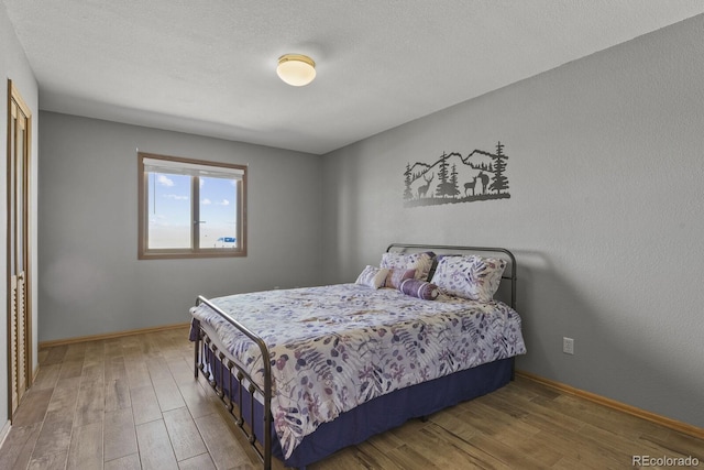 bedroom featuring hardwood / wood-style floors and a textured ceiling