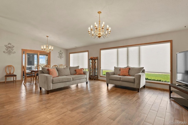 living room with light hardwood / wood-style floors, a wealth of natural light, and a chandelier