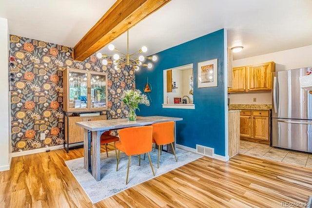 1152 S Yosemite Way Unit 29, Denver, CO 80247 - dining space with light wood-style floors, a chandelier, wallpapered walls, and beamed ceiling