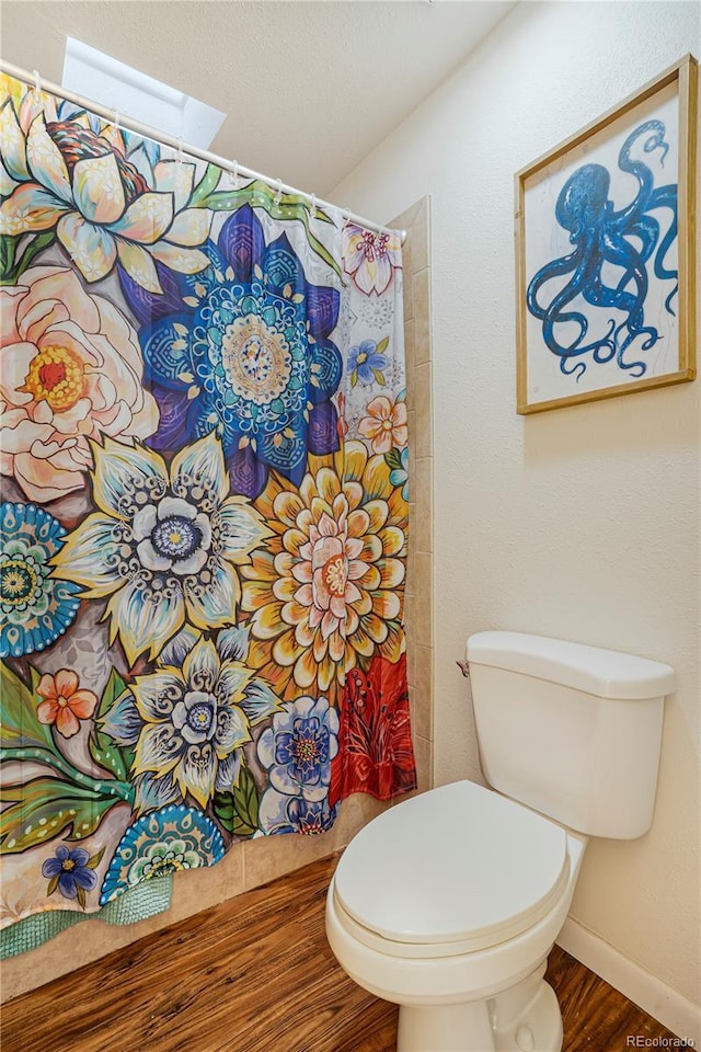 1152 S Yosemite Way Unit 29, Denver, CO 80247 - bathroom with wood finished floors, a skylight, and a shower with shower curtain