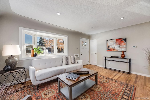 living room with hardwood / wood-style floors and a textured ceiling