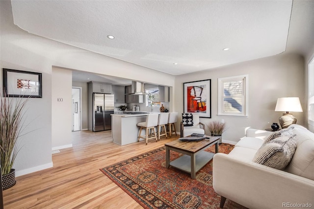 living room with a textured ceiling and light wood-type flooring