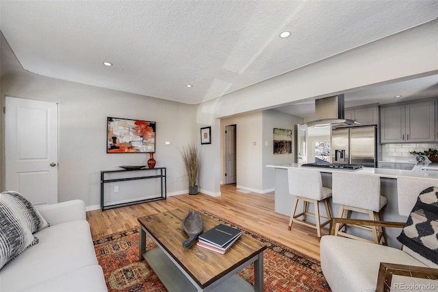 living room with a textured ceiling and light wood-type flooring