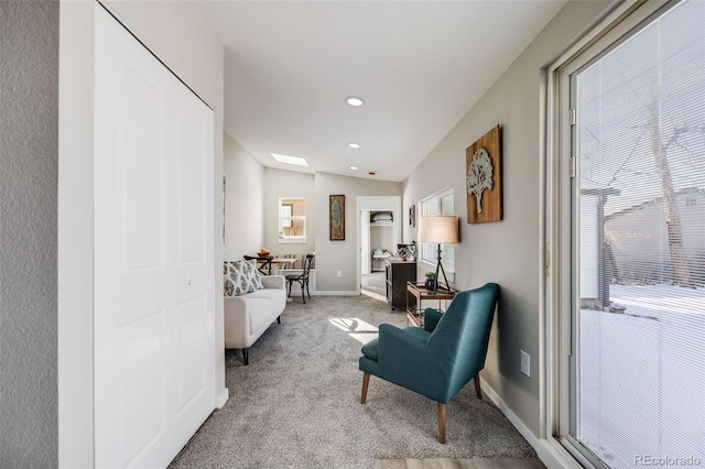 sitting room with light carpet, vaulted ceiling, and plenty of natural light