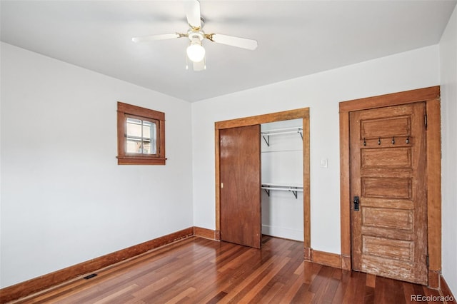 unfurnished bedroom featuring ceiling fan, a closet, and dark hardwood / wood-style floors