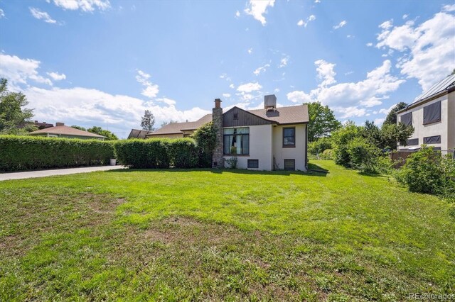 675 Holland St, Lakewood, CO 80215 - back of house featuring a lawn and a chimney