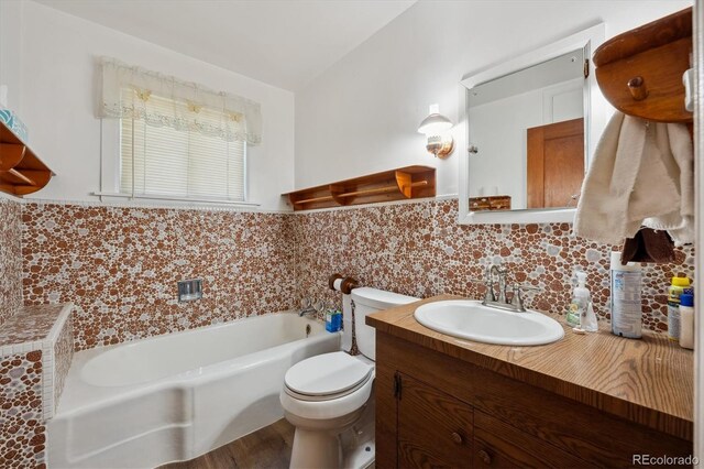 675 Holland St, Lakewood, CO 80215 - bathroom featuring a tub, decorative backsplash, and vanity