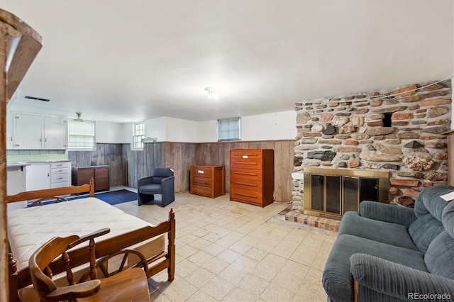675 Holland St, Lakewood, CO 80215 - living room with a stone fireplace, wainscoting, and wooden walls