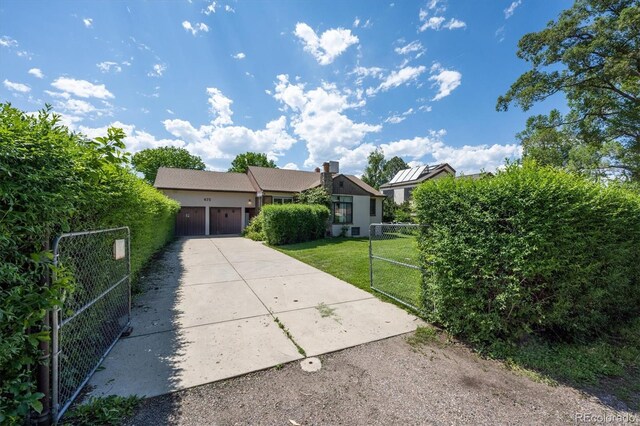 675 Holland St, Lakewood, CO 80215 - view of front of house with concrete driveway, a gate, an attached garage, and stucco siding