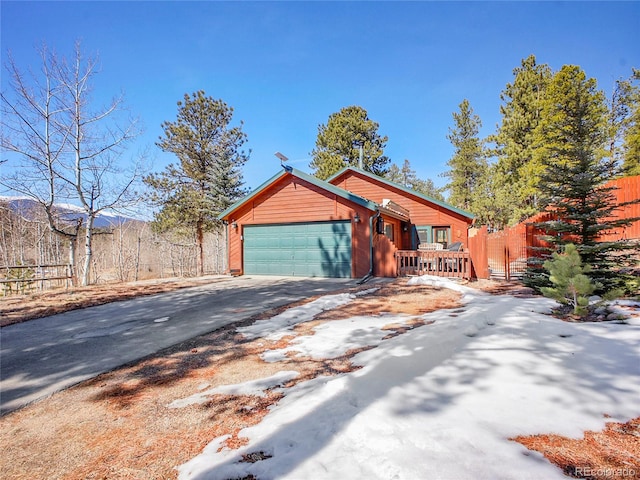 view of front of home with aphalt driveway, a garage, and fence