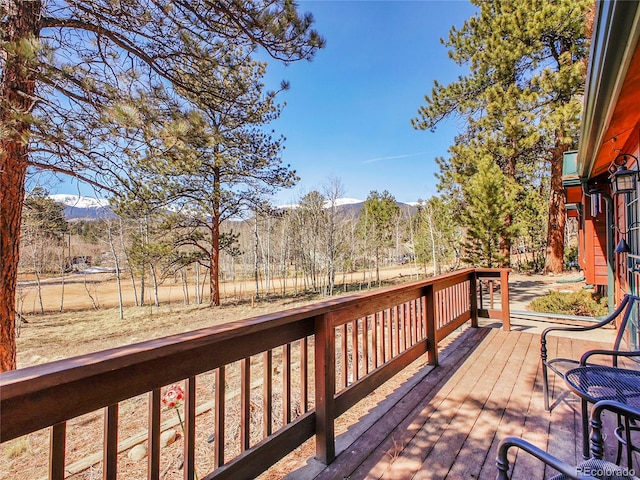 deck with a forest view and a mountain view