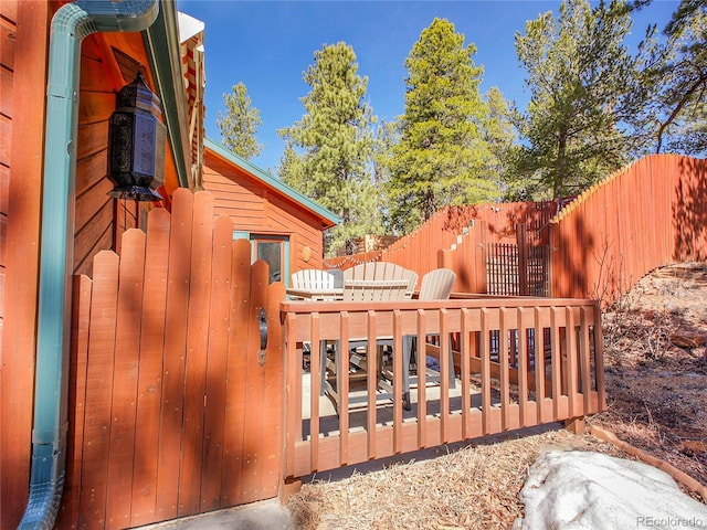 view of gate with a deck and fence