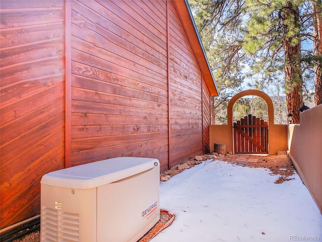 view of side of home featuring fence and a gate