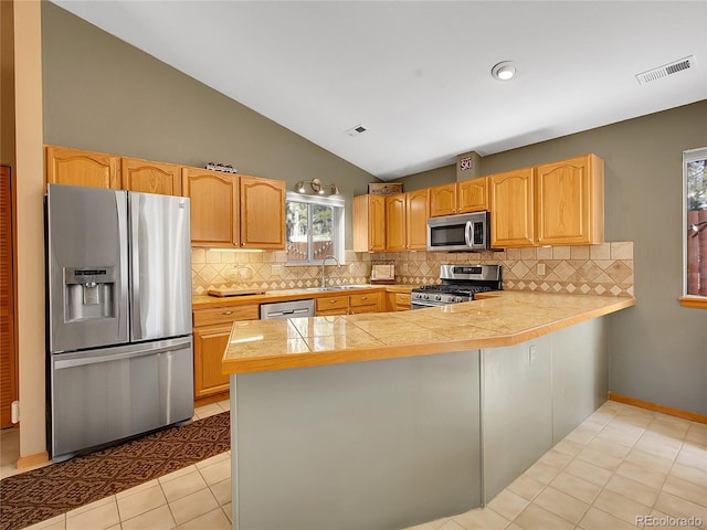 kitchen with visible vents, appliances with stainless steel finishes, a peninsula, and a sink