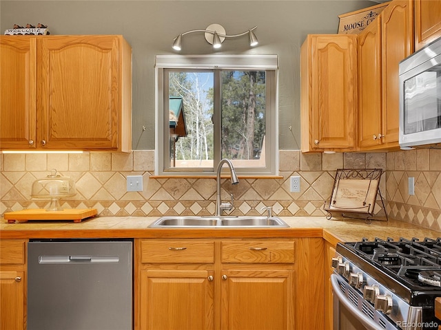 kitchen featuring decorative backsplash, tile countertops, stainless steel appliances, and a sink