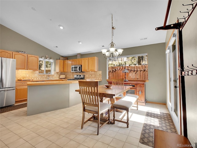 dining room with visible vents, a chandelier, and vaulted ceiling