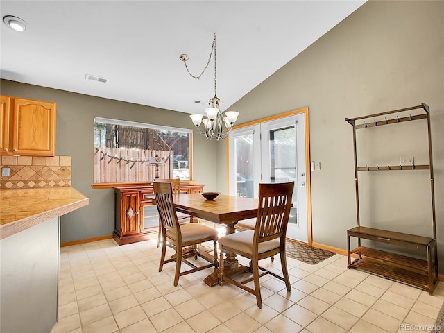 dining area with visible vents, a notable chandelier, baseboards, light tile patterned flooring, and lofted ceiling