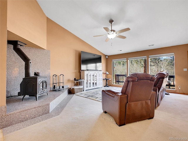 living area featuring visible vents, high vaulted ceiling, carpet flooring, ceiling fan, and a wood stove