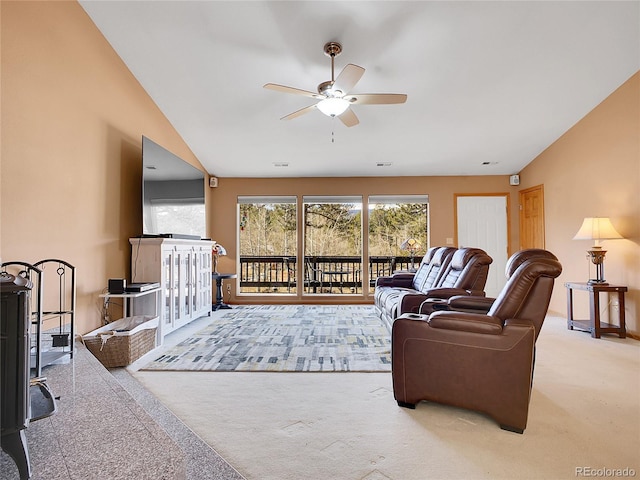 living area with carpet flooring, baseboards, a ceiling fan, and vaulted ceiling