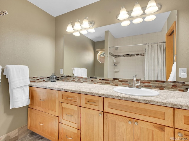 bathroom with vanity, tasteful backsplash, and tiled shower