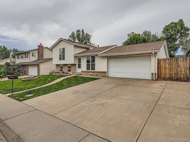 380 S 25th Ave, Brighton, CO 80601 - split level home featuring a garage, concrete driveway, and brick siding